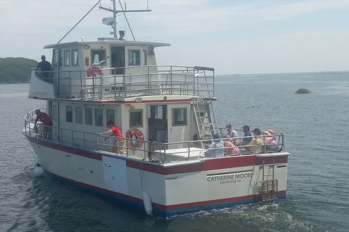 A boat named 'Catherine Moore' on water with people on deck.