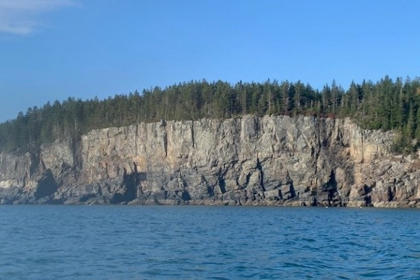 a large body of water with a mountain in the background