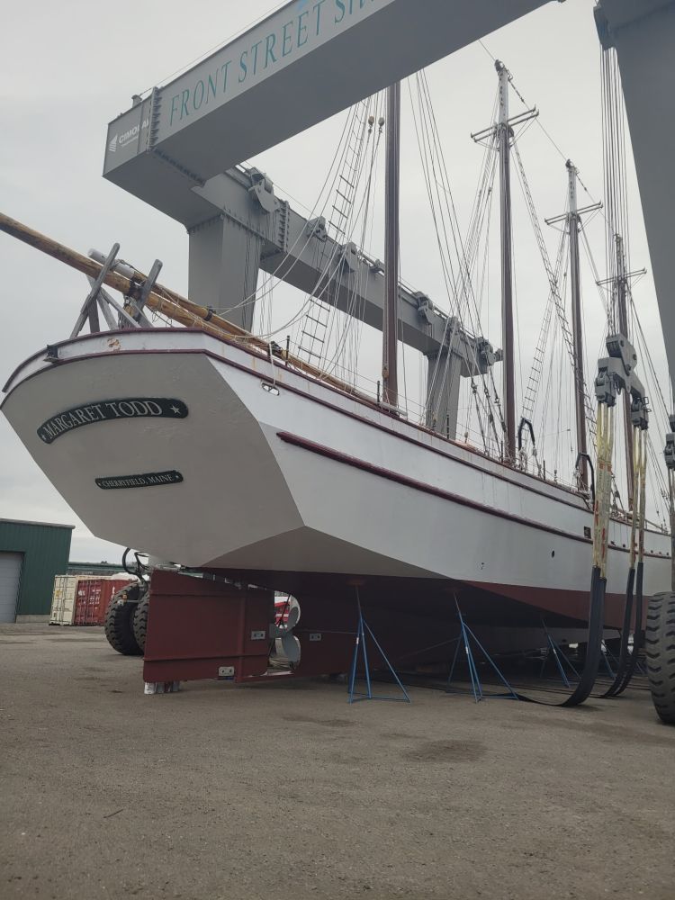 Large sailboat on dry dock with support structures.